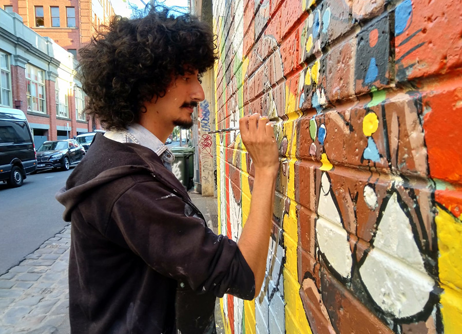 Artist painting a mural in Fitzroy